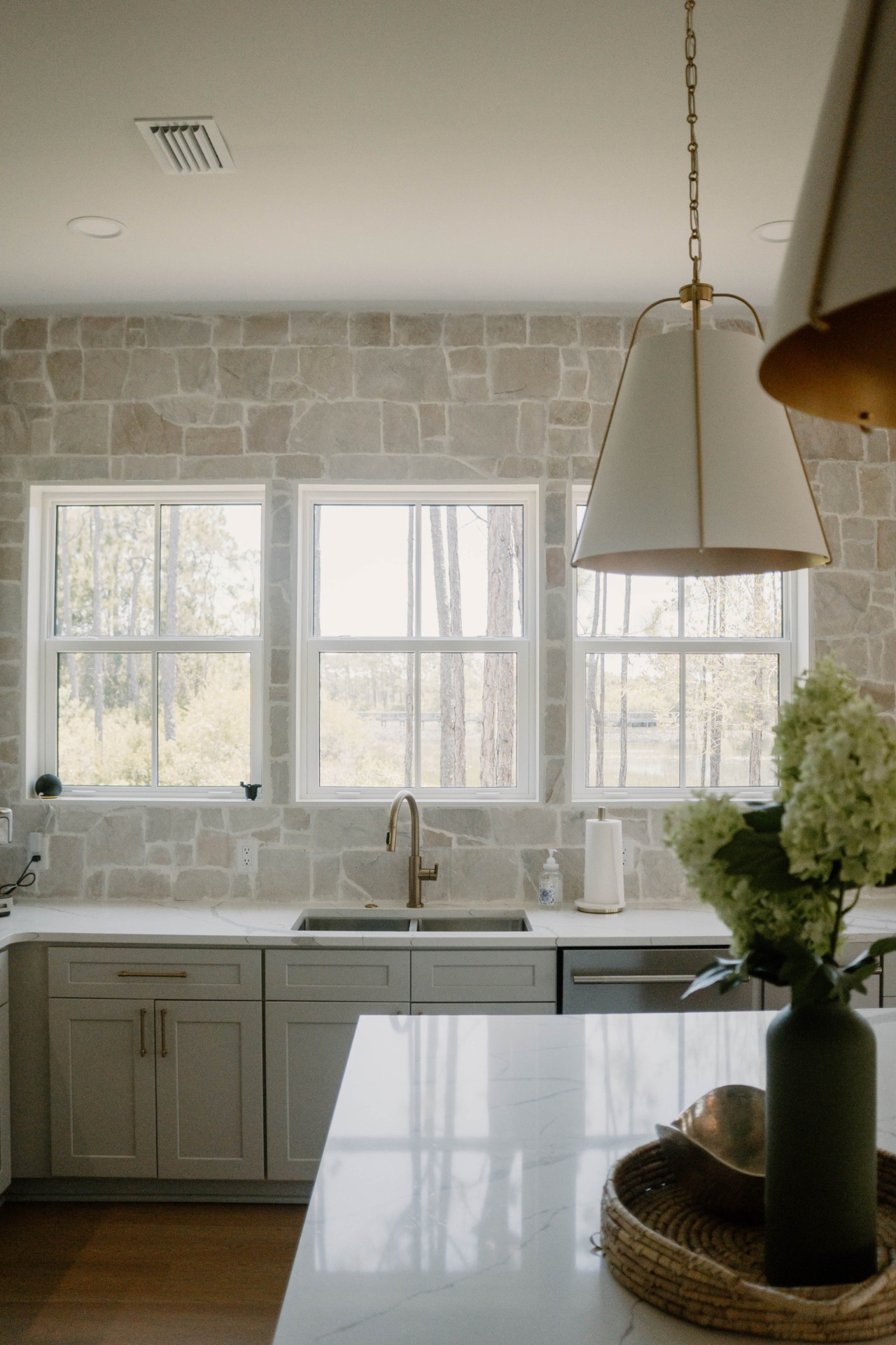 Kitchen sink with stone wall and lake-view windows