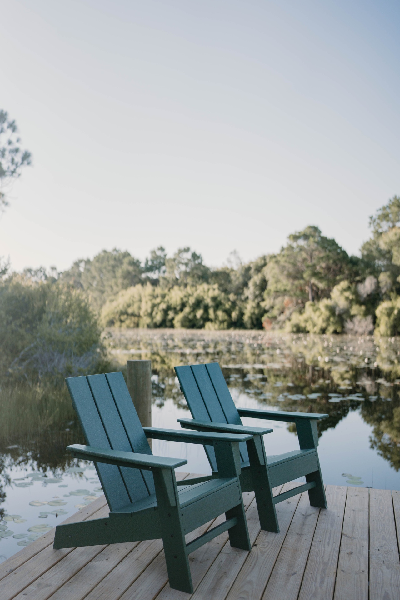 Adirondack chairs on the dock at golden hour